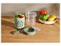 Récipient alimentaire avec une fourchette, une tasse transparente et un bol de légumes frais et de citrons.