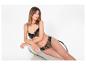 Femme en soutien-gorge et culotte léopard, assise sur une chaise.