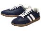 Een paar donkerblauwe sneakers met witte strepen en bruine zolen.