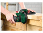 Een groene schuurmachine wordt gebruikt om hout te schuren.