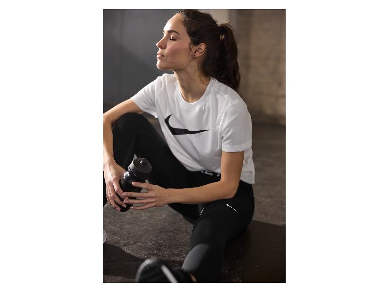 Nike: wit t-shirt, zwarte leggings en waterfles.