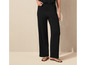 Pantalon large noir avec des sandales beiges.