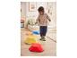 Enfant heureux jouant avec des pas colorés sur un sol en bois.