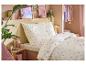Chambre avec housse de couette florale, drap-housse fraise et objets décoratifs.