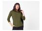 Vrouw in een olijfgroene top met lange mouwen en zwarte broek, met een zwarte jas.