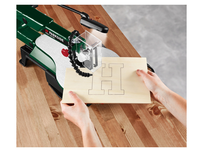 Een Parkside decoupeerzaag snijdt een houten letter H uit.