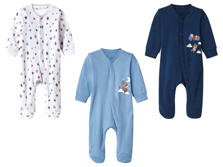 Trois grenouillères pour bébé: blanche à étoiles, bleu clair avec un ours et un renard, et bleu foncé avec un ours et des ballons.
