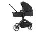 Een zwarte kinderwagen met een wieg en een boodschappenmand.