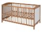 Un lit bébé en bois avec des barreaux.