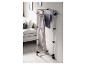 Verticaal wasrek met broeken en shirts in een moderne woonkamer.