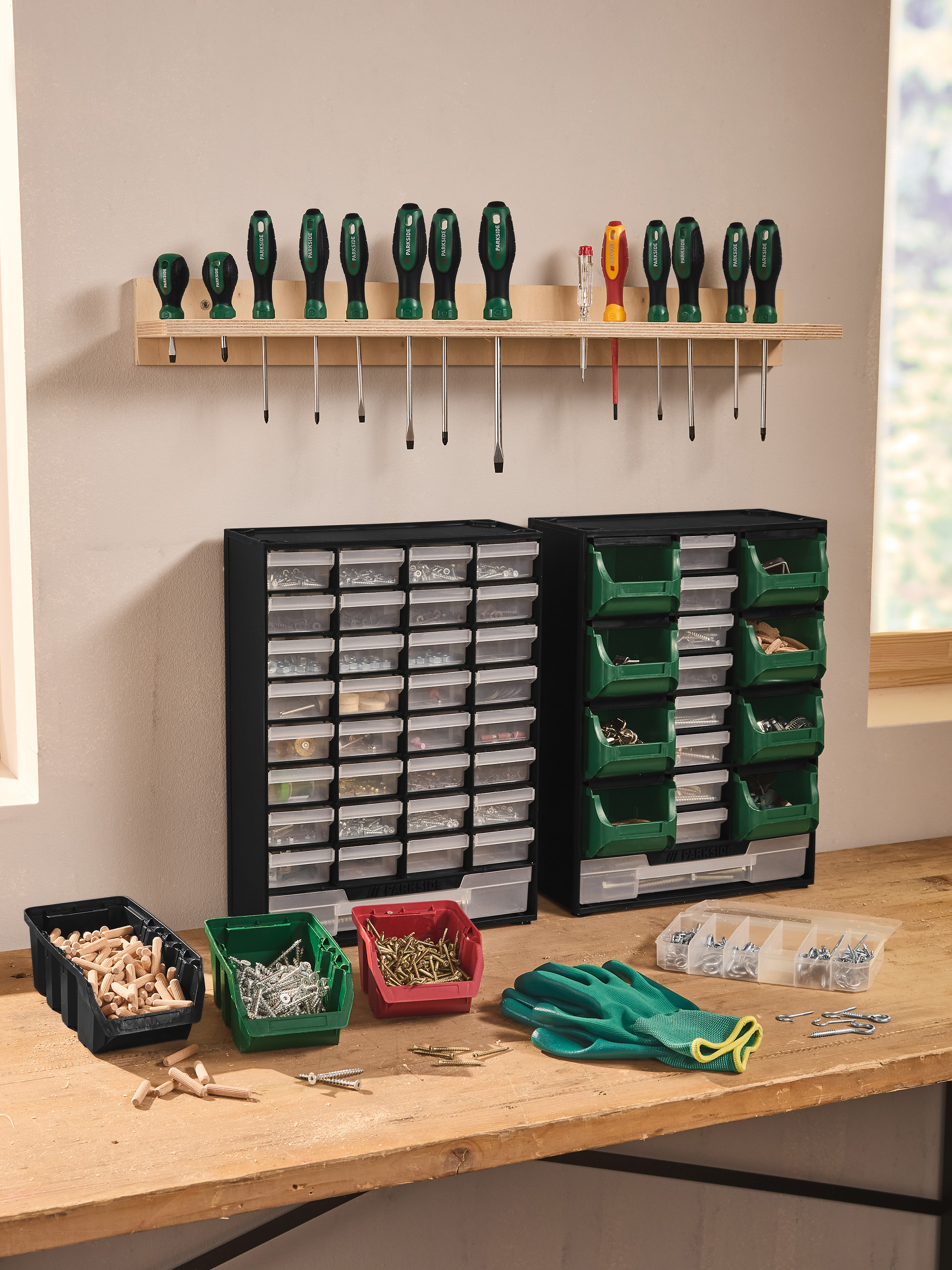 Garagewerkbank met schroevendraaiers, opbergdozen en diverse accessoires.