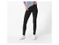 Vrouw draagt zwarte leggings en witte sneakers, met een lichtblauwe top.