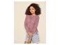 Femme en cardigan en maille ajourée lilas et short en jean.