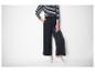 Femme portant un haut rayé noir et blanc et un pantalon large noir.
