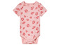 Een roze babypakje met korte mouwen en rode bloemenprint.