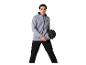 Homme en sweat à capuche gris et pantalon de survêtement noir, tenant un ballon noir