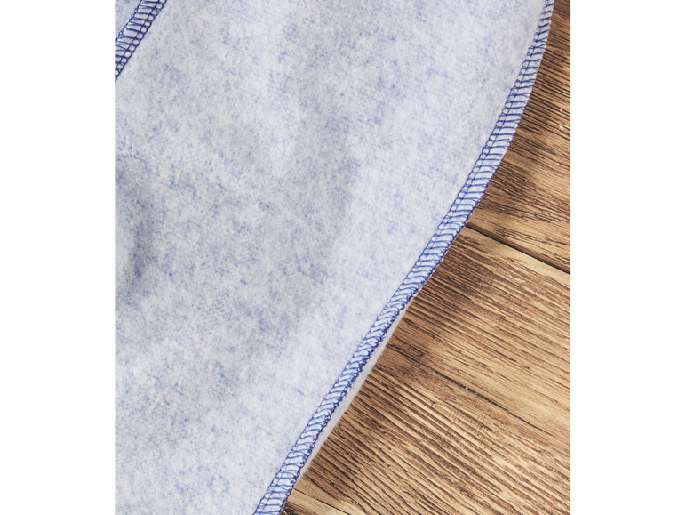 Détail d'un tissu en polaire bleu avec une couture bleue