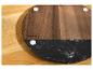 Ronde SilverCrest serveerplank van hout en zwart marmer op een houten tafel.