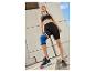 Vrouw in Crivit sportkleding, sneakers en kniebrace.