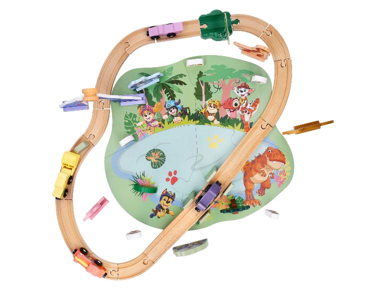 Houten treinbaan met tekenfilmfiguren en een dinosaurus op een speelmat.