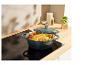 Cocotte Staub avec poulet rôti sur une plaque à induction.