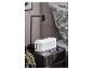 Table de chevet noire avec une lampe de table, une boîte à câbles blanche et un smartphone en charge.