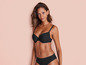 Une femme porte un soutien-gorge et une culotte noirs.