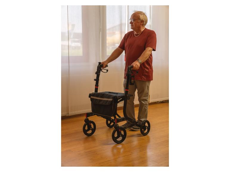 Un homme marchant avec un déambulateur avec un sac.