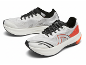 Paar witte en zwarte hardloopschoenen met oranje accenten.