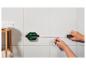 Un mètre laser Parkside mesure une ligne sur un mur carrelé.