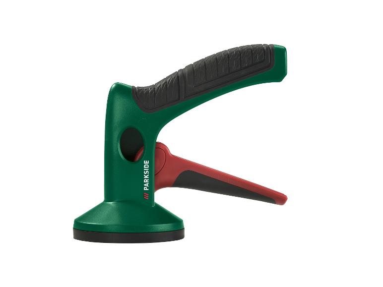 Un outil à ventouse vert et rouge avec une poignée noire texturée.