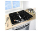 Deux protections de plaques de cuisson noires sur une cuisinière à gaz.