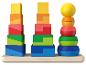 Trois tours de jouets empilables aux couleurs vives sur une étagère en bois.