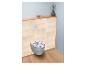 Toilettes avec abattant à motifs bleus et blancs dans une salle de bain lambrissée de bois clair.