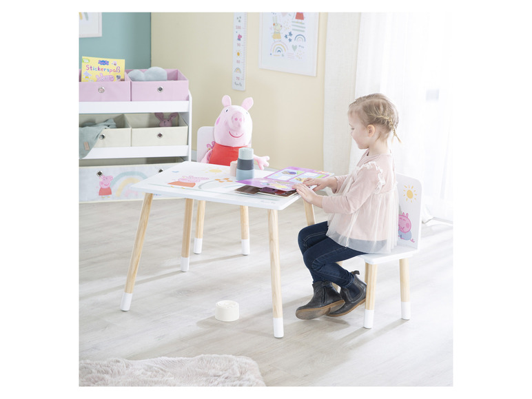 Un enfant assis à une table et une chaise Peppa Pig, prêt à jouer.