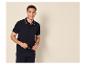 Lachende man in marineblauwe poloshirt en broek, met bril.
