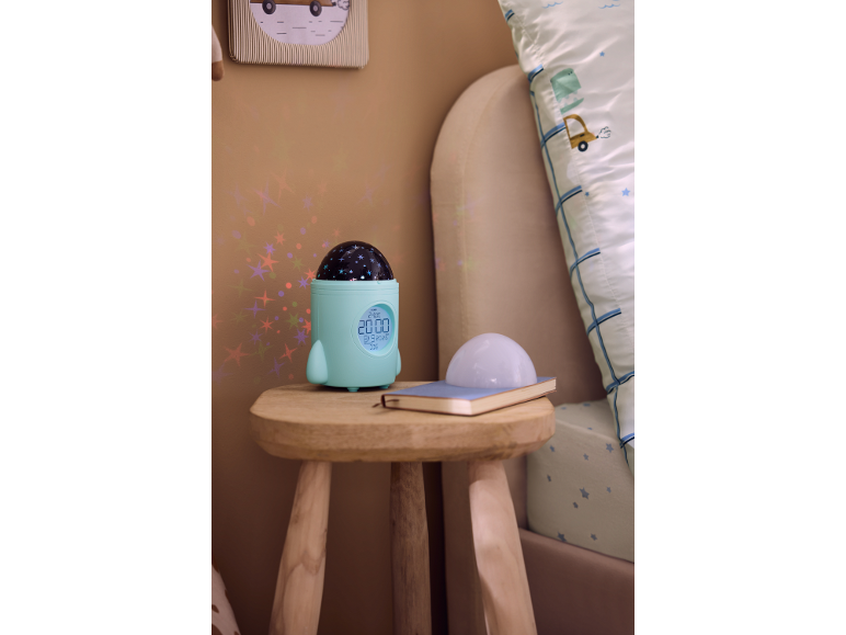 Réveil pour enfant en forme de fusée avec projecteur d'étoiles sur une table de chevet