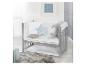 Un lit bébé gris avec une literie blanche à motifs d'étoiles et de lunes, des oreillers décoratifs et un tapis moelleux.