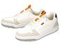 Witte sneakers met oranje accenten en grijze zool