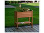 Een houten plantenbak met planten en een onderlegger op een terras.