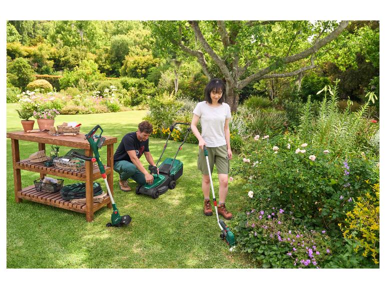 Paar in de tuin met grasmaaier, trimmer en tuintafel met gereedschap.