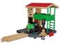 Houten treinset met een groene locomotief, station en werkervoorbeeld.