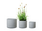 Trois pots ronds gris avec une texture rugueuse.