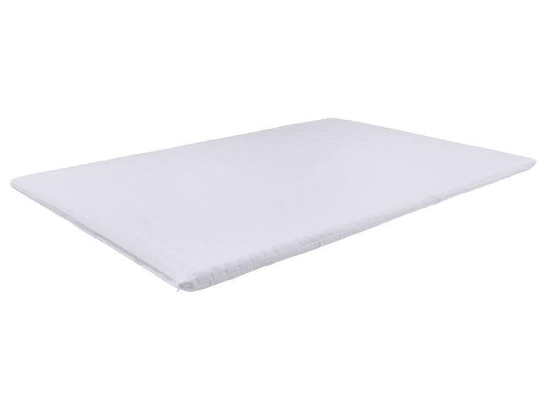 Witte matrastopper met een gestreepte textuur en een rits aan de zijkant.