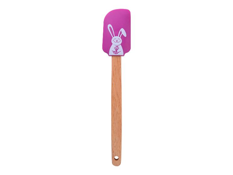 Een roze siliconen spatel met een konijn erop, met een houten handvat.
