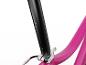 Close-up van een roze fietsframe met een zwarte zadelpen met genummerde verstelmarkeringen.