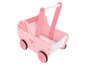 Une poussette en bois rose pour poupées avec des cœurs.