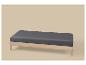 Un banc en bois moderne avec un coussin gris foncé sur un fond beige clair.