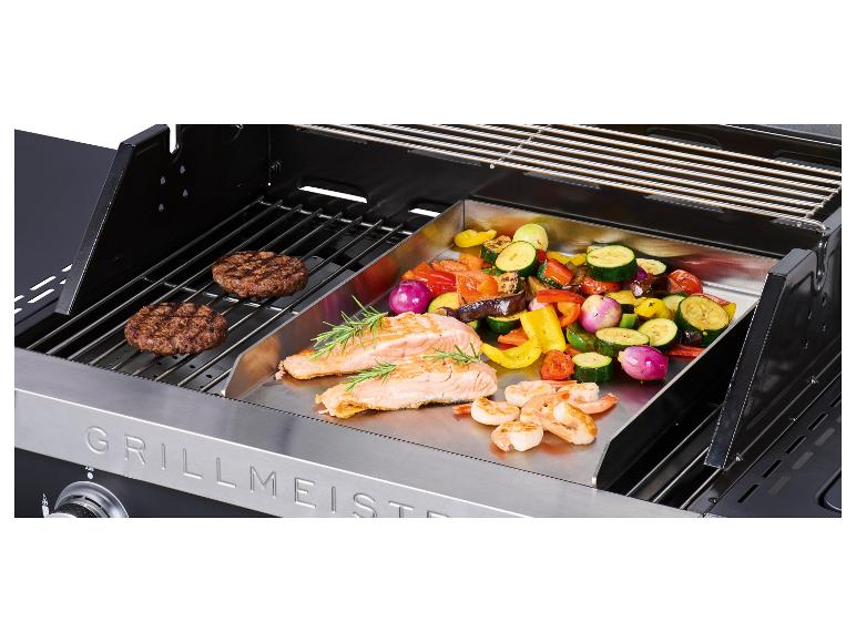 Gasbarbecue met hamburgers, zalm, garnalen en groenten op een bakplaat.
