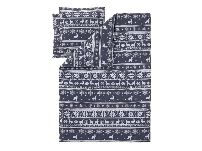 Parure de lit bleu foncé avec motif de rennes blancs et flocons de neige.